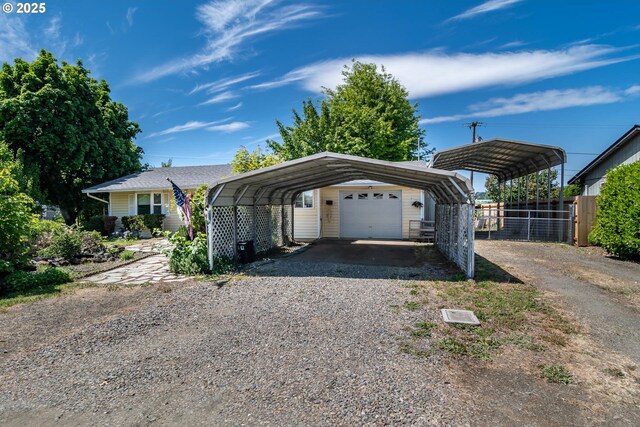 view of parking / parking lot with a carport, gravel driveway, and fence
