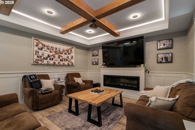 living room with coffered ceiling, wood finished floors, and wainscoting