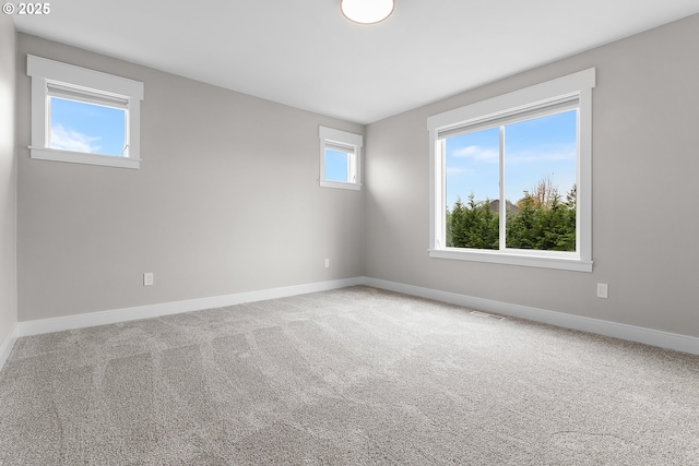 unfurnished room featuring carpet floors, baseboards, and visible vents
