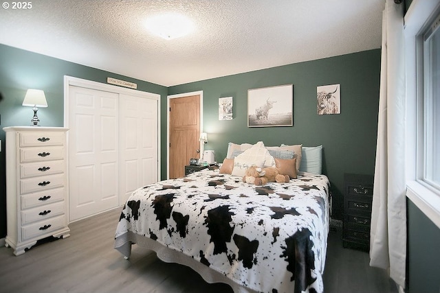 bedroom featuring a textured ceiling, a closet, and light wood-type flooring