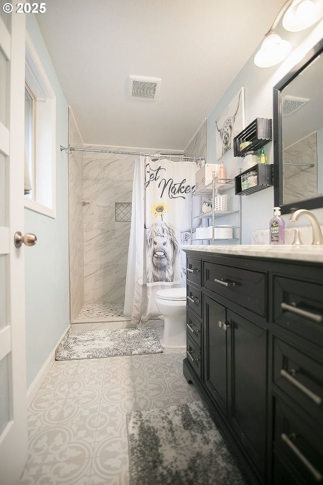 bathroom with toilet, a tile shower, vanity, and visible vents