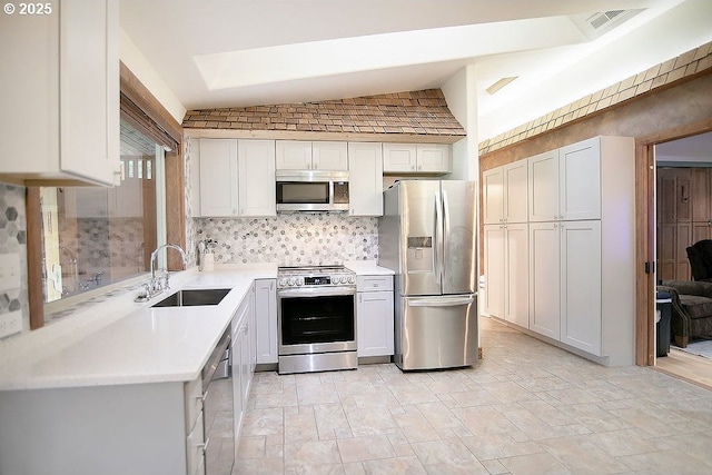 kitchen featuring stainless steel appliances, visible vents, a sink, backsplash, and light countertops