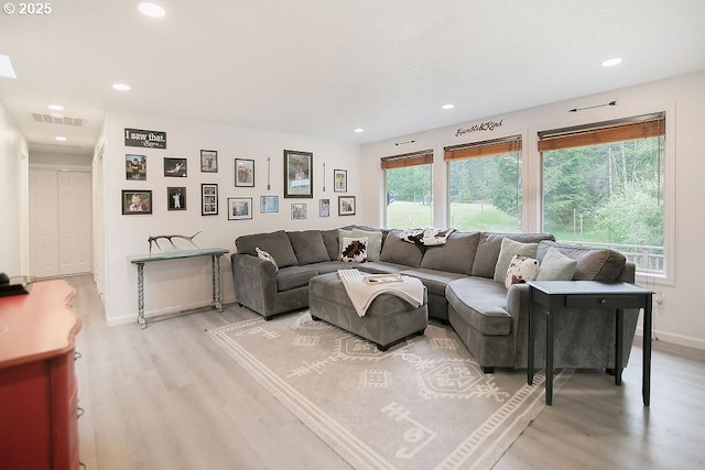 living room featuring light wood-style floors, visible vents, baseboards, and recessed lighting