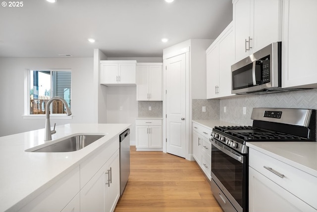 7864 NW Eleanor Ave, Portland, OR 97229 - kitchen with appliances with stainless steel finishes, a sink, light wood finished floors, and light countertops