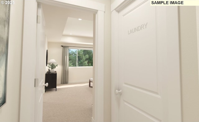 hall with carpet flooring, recessed lighting, and a raised ceiling