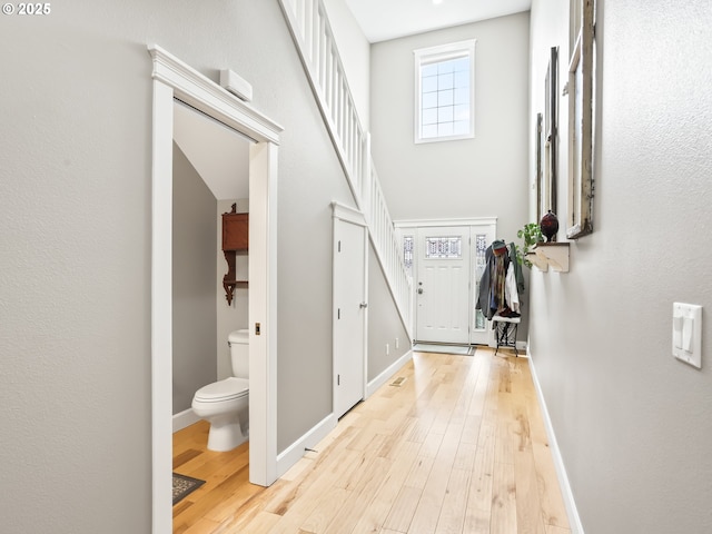 foyer entrance featuring a high ceiling and light hardwood / wood-style flooring