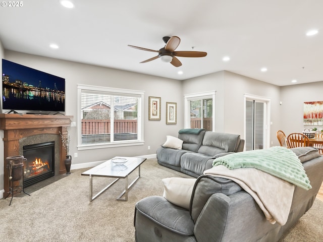 carpeted living room featuring ceiling fan and a high end fireplace