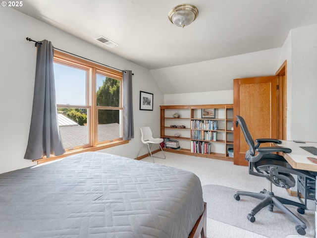 carpeted bedroom with visible vents and vaulted ceiling