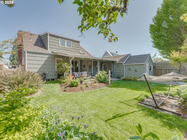 rear view of house featuring a patio, fence, a shingled roof, an outdoor hangout area, and a yard