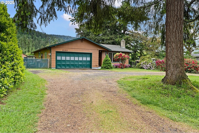 8157 Thurston Rd, Springfield, OR 97477 - view of front of home with dirt driveway, a garage, and a chimney