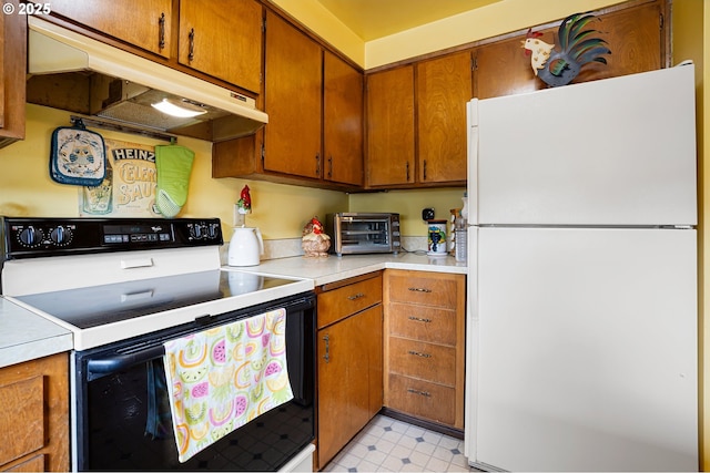 8157 Thurston Rd, Springfield, OR 97477 - kitchen with freestanding refrigerator, range with electric cooktop, under cabinet range hood, light countertops, and brown cabinets