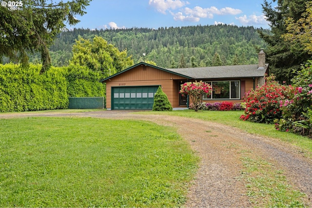 8157 Thurston Rd, Springfield, OR 97477 - view of front of home featuring a wooded view, dirt driveway, a chimney, and an attached garage
