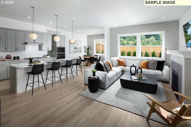 living room with sink and light wood-type flooring