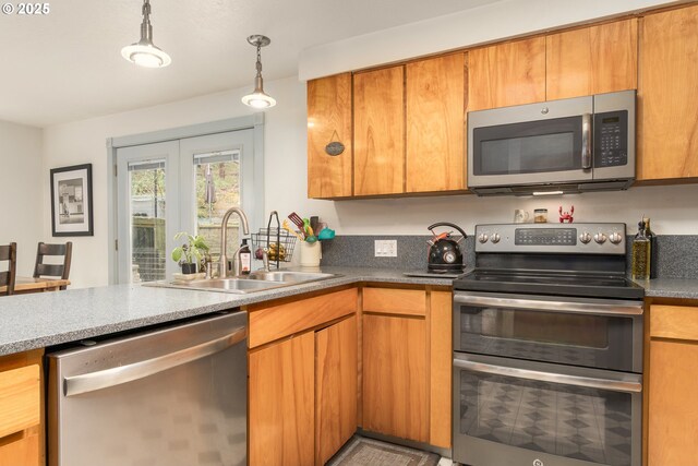 29536 Simmons Rd, Eugene, OR 97405 - kitchen with appliances with stainless steel finishes, a sink, brown cabinetry, pendant lighting, and french doors