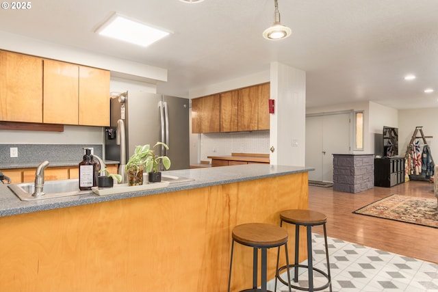 29536 Simmons Rd, Eugene, OR 97405 - kitchen featuring freestanding refrigerator, a sink, a kitchen breakfast bar, light wood finished floors, and dark countertops