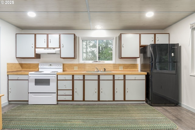 29536 Simmons Rd, Eugene, OR 97405 - kitchen with white electric range, freestanding refrigerator, under cabinet range hood, a sink, and light wood-style floors