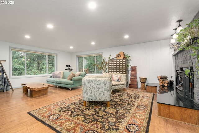 living room featuring recessed lighting, a fireplace, and light wood-style floors