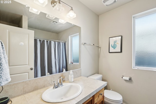 full bath featuring toilet, plenty of natural light, visible vents, and vanity