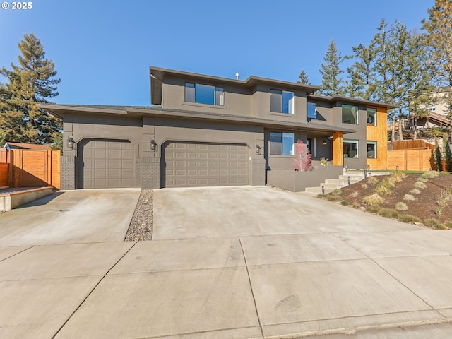 prairie-style home featuring brick siding, fence, and driveway