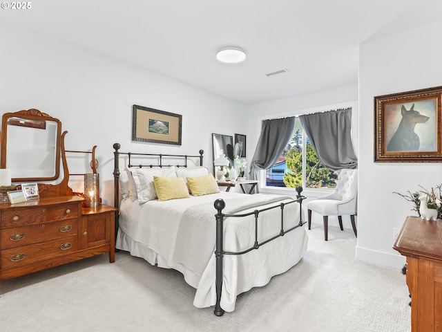 bedroom with light colored carpet, visible vents, and baseboards