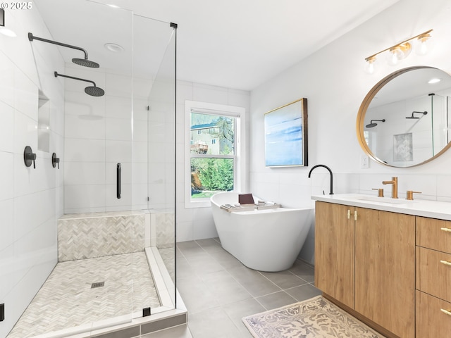 full bathroom with tile walls, a soaking tub, a shower stall, vanity, and tile patterned floors