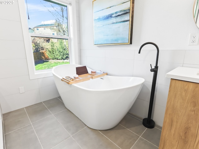 full bathroom with a soaking tub, tile walls, and tile patterned floors