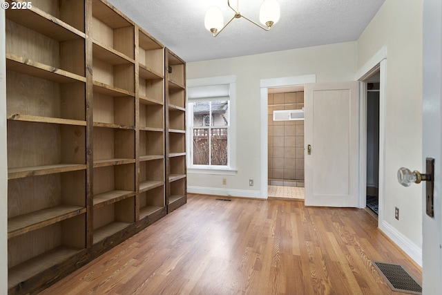 4903 SE Haig St, Portland, OR 97206 - unfurnished bedroom with wood finished floors, a chandelier, and a textured ceiling