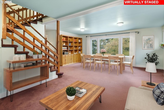 carpeted living area with baseboards and stairs