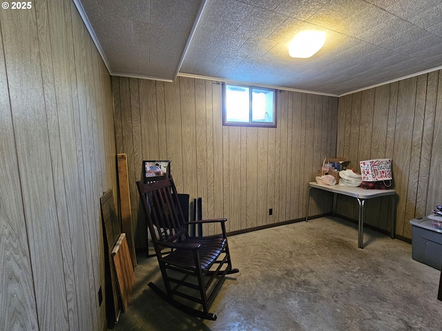 sitting room featuring baseboards, carpet flooring, and wooden walls