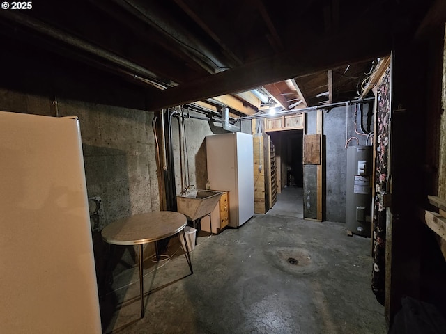 unfinished basement with freestanding refrigerator, water heater, and a sink