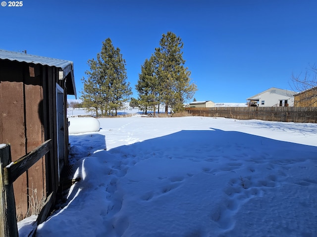 snowy yard featuring fence