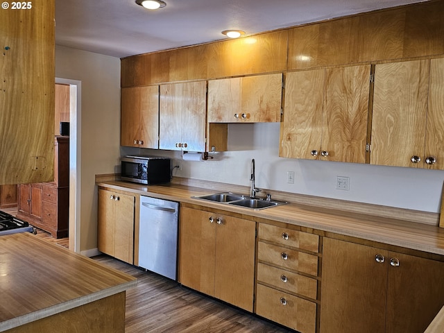 kitchen featuring stainless steel appliances, brown cabinetry, dark wood-type flooring, and a sink