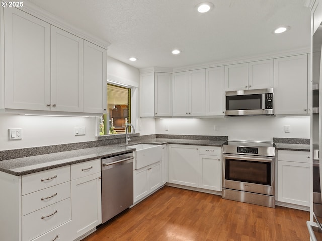 1675 NW 1st St, Gresham, OR 97030 - kitchen featuring stainless steel appliances, white cabinetry, light wood-style floors, and recessed lighting