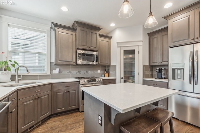 kitchen featuring a sink, dark wood-style floors, tasteful backsplash, and stainless steel appliances