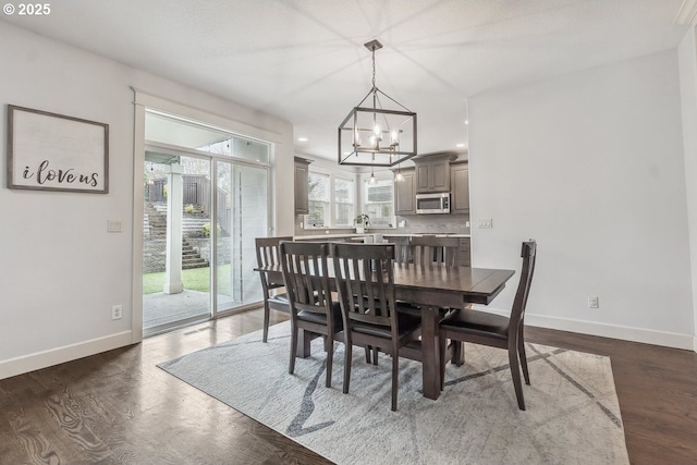 dining space featuring a notable chandelier, recessed lighting, dark wood-style floors, and baseboards