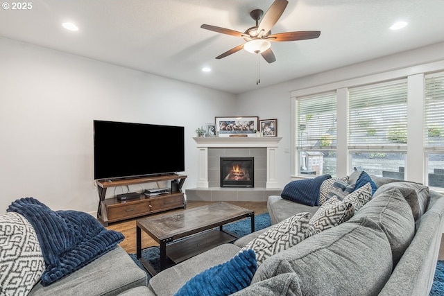 living area with recessed lighting, a tile fireplace, and wood finished floors