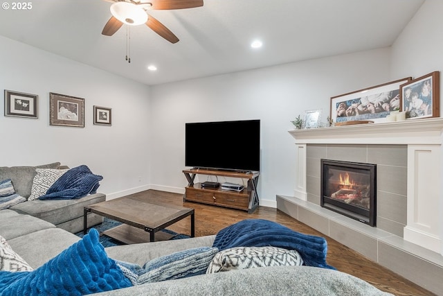 living area with baseboards, a tiled fireplace, recessed lighting, wood finished floors, and a ceiling fan