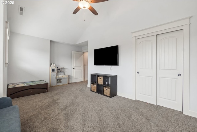 carpeted living room with a ceiling fan, visible vents, and high vaulted ceiling