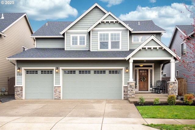 craftsman house with stone siding, driveway, and a shingled roof