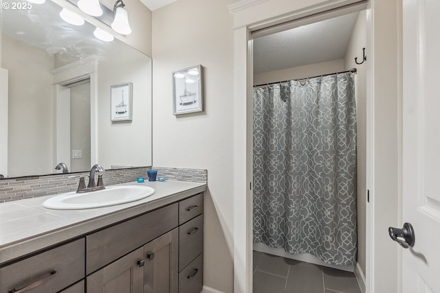 full bath featuring tile patterned floors, backsplash, a shower with shower curtain, and vanity