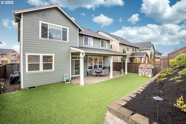 rear view of property with a patio, a lawn, and a fenced backyard