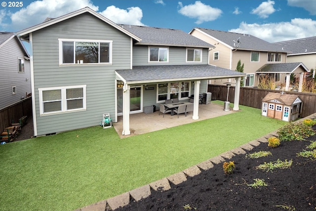 back of property featuring a patio, a yard, a fenced backyard, and roof with shingles