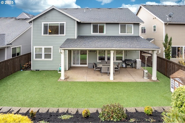 rear view of property featuring a yard, a fenced backyard, a patio area, and roof with shingles