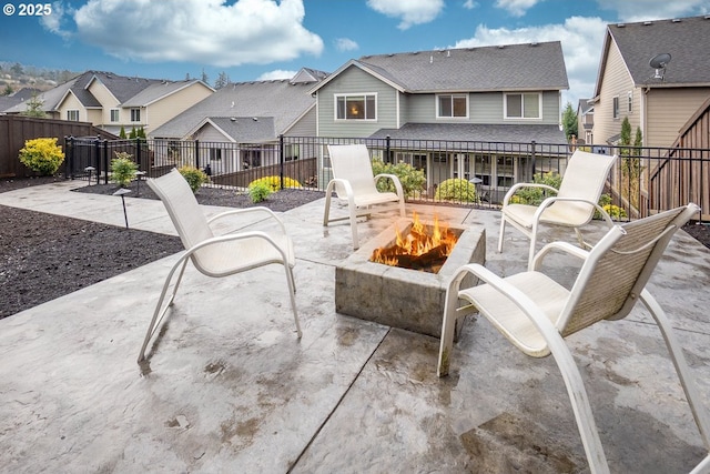 view of patio featuring a residential view, a fire pit, and a fenced backyard