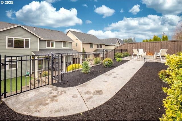 view of yard with a gate, a patio area, a residential view, and a fenced backyard