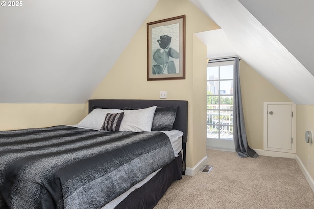 bedroom featuring light colored carpet and vaulted ceiling