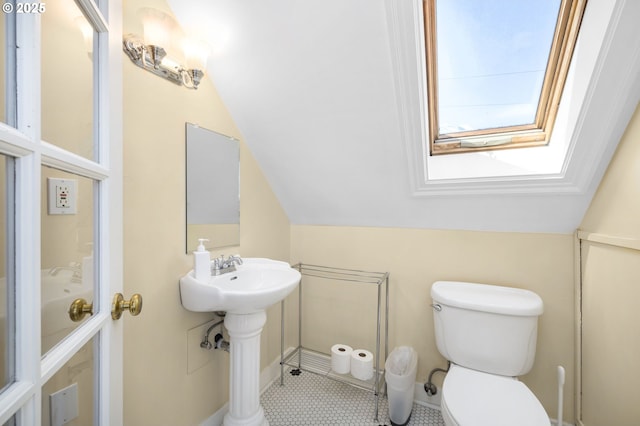 bathroom featuring lofted ceiling and toilet