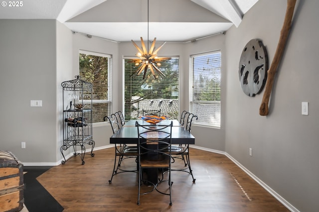 dining space featuring dark wood-style floors, vaulted ceiling, a chandelier, and baseboards
