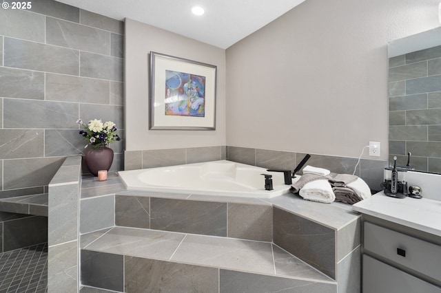 bathroom featuring a garden tub and vanity