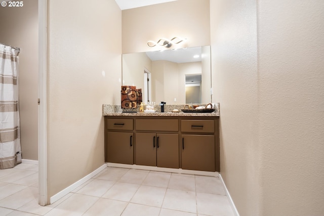 bathroom with curtained shower, tile patterned flooring, vanity, and baseboards